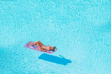 Büyük yüzme havuzunda bikini hava şilte genç kadın