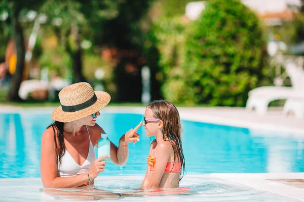 Joven madre aplicando crema solar a la nariz de la hija — Foto de Stock