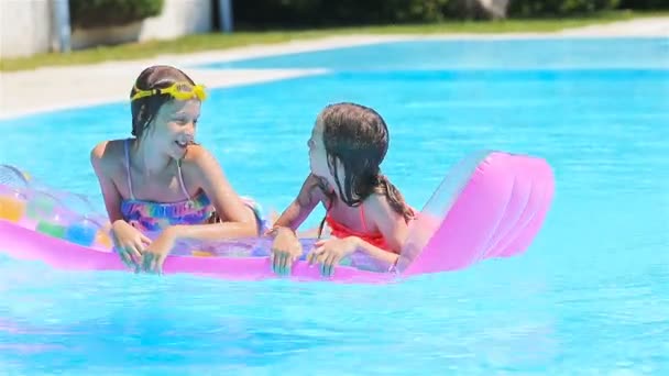 Adorable little sisters play in outdoor swimming pool — Stock Video