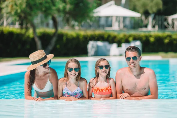 Szczęśliwa czteroosobowa rodzina w basenie na świeżym powietrzu — Zdjęcie stockowe