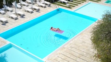 Büyük yüzme havuzunda bikini hava şilte genç kadın