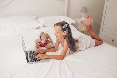 Dizüstü bilgisayarda ödev yapan sevimli küçük kız.