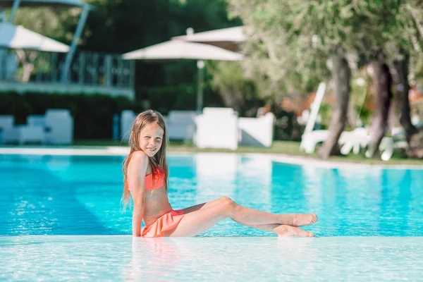 Μικρό αξιολάτρευτο κορίτσι στην εξωτερική πισίνα — Φωτογραφία Αρχείου