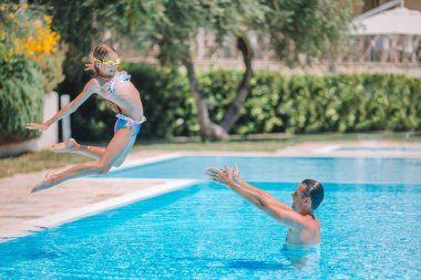 Mutlu aile açık havada yüzme havuzunda beraber eğleniyor