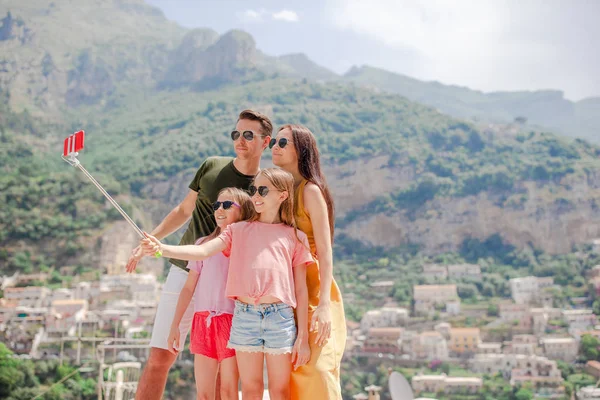 Los padres y los niños tomando foto de fondo de selfie Positano ciudad en Itali en la costa de Amalfi —  Fotos de Stock