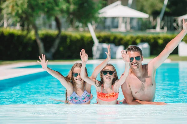 Szczęśliwa czteroosobowa rodzina w basenie na świeżym powietrzu — Zdjęcie stockowe