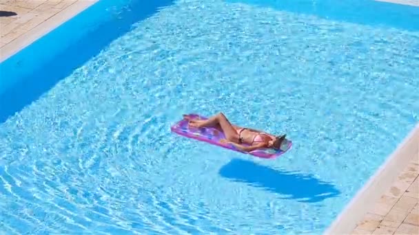 Mujer joven en bikini colchón de aire en la gran piscina — Vídeos de Stock