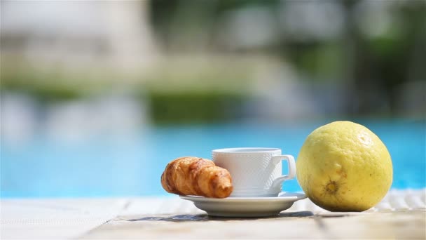 Leckeres Frühstück Zitrone, Kaffee, Croissant am Pool — Stockvideo