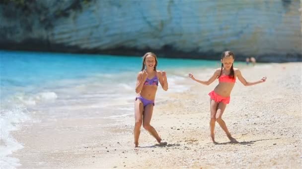 Niñas divirtiéndose en la playa tropical durante las vacaciones de verano — Vídeo de stock
