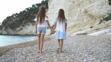 Küçük kızlar yaz tatilinde tropik plajda eğleniyorlar.