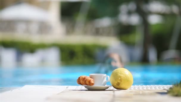 Deliziosa colazione limone, caffè, croissant a bordo piscina — Video Stock