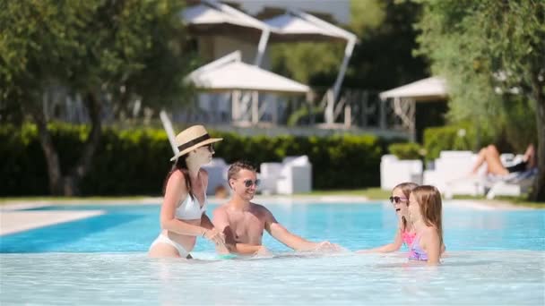 Šťastná čtyřčlenná rodina ve venkovním bazénu — Stock video