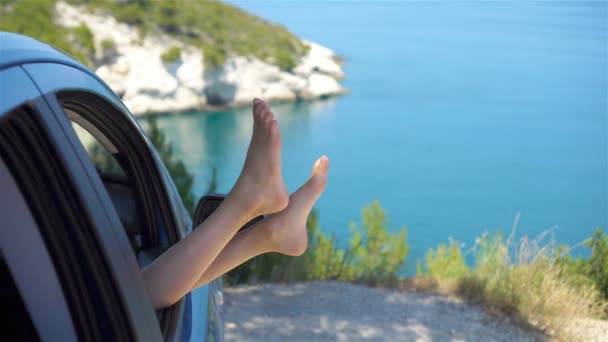 Close up van weinig meisje voeten tonen van de auto venster achtergrond zee — Stockvideo