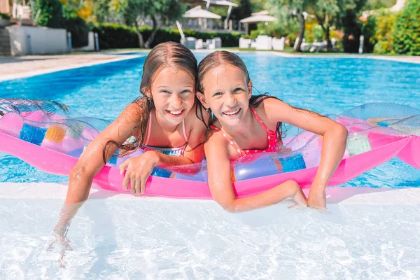Adorable little sisters play in outdoor swimming pool — Stock Photo, Image