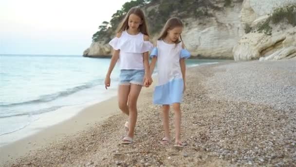 Küçük kızlar yaz tatilinde tropik plajda eğleniyorlar. — Stok video