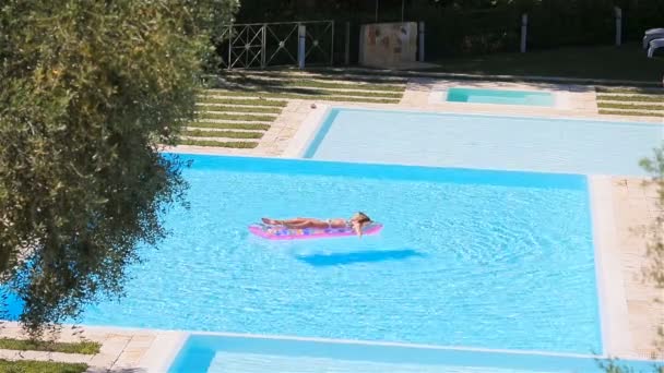 Jeune femme en bikini matelas à air dans la grande piscine — Video