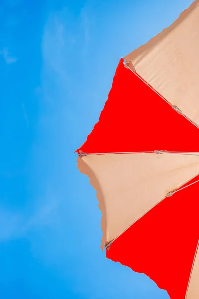 Primo piano di un ombrellone rosso e giallo su sfondo di cielo azzurro — Foto Stock