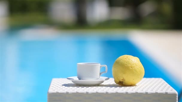 Pyszne śniadanie cytryna, kawa, rogalik przy basenie — Wideo stockowe