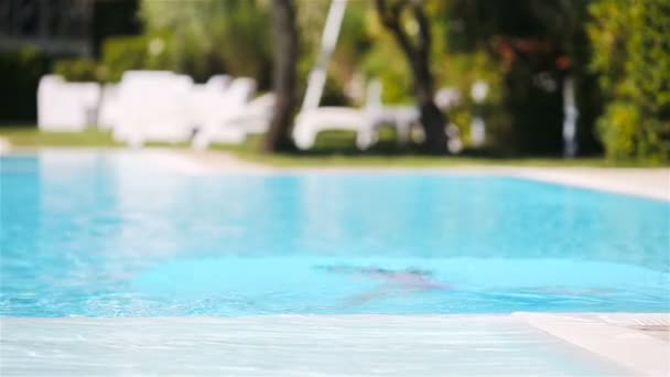 Urocza dziewczynka pływająca na odkrytym basenie — Wideo stockowe