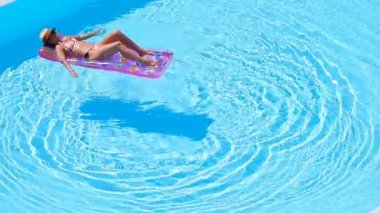 Büyük yüzme havuzunda bikini hava şilte genç kadın