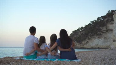 Kumsalda çocukları olan mutlu bir aile.
