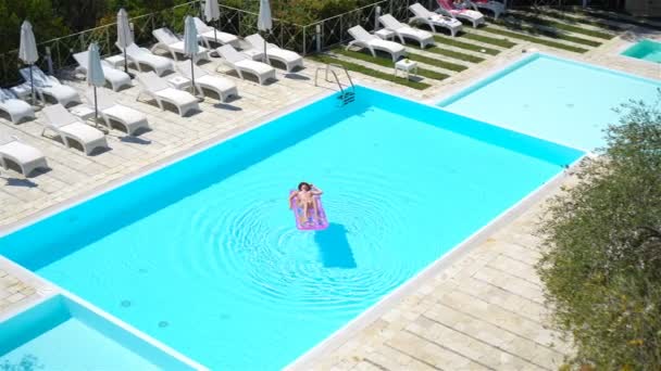 Büyük yüzme havuzunda bikini hava şilte genç kadın — Stok video