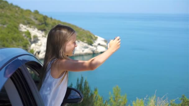 Dziewczynka na wakacyjne wyjazdy samochodem pięknym krajobrazem w tle — Wideo stockowe