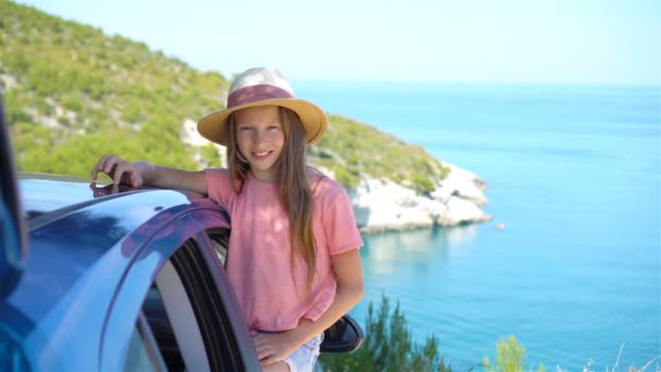 Маленькая девочка на отдыхе путешествия на автомобиле фоне красивый пейзаж — стоковое видео