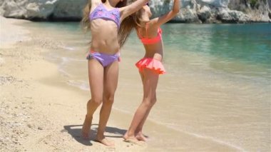 Küçük kızlar yaz tatilinde tropik plajda eğleniyorlar.