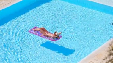 Büyük yüzme havuzunda bikini hava şilte genç kadın