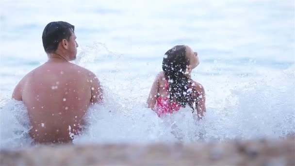 Glücklicher Vater und seine entzückende kleine Tochter am Strand — Stockvideo