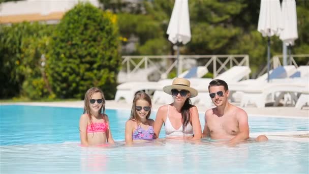 Щаслива сім'я з чотирьох у відкритому басейні — стокове відео