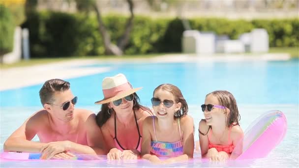 Happy family of four in outdoors swimming pool — Stock Video