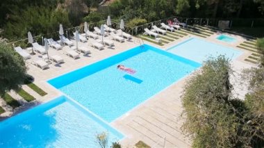 Büyük yüzme havuzunda bikini hava şilte genç kadın