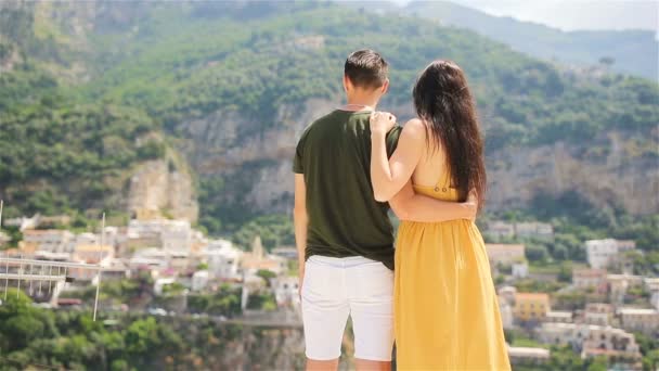 Férias de verão na Itália. Casal jovem em Positano aldeia ao fundo, Costa Amalfitana, Itália — Vídeo de Stock