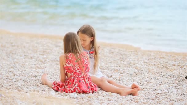 Маленькі дівчата розважаються на тропічному пляжі під час літніх канікул — стокове відео