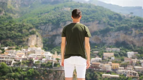 Nyaralás Olaszországban. Fiatal férfi Positano faluban a háttérben, Amalfi Coast, Olaszország — Stock videók
