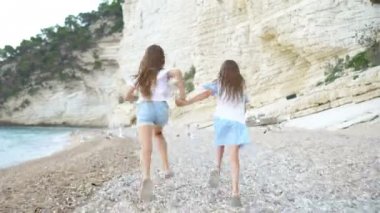Küçük kızlar yaz tatilinde tropik plajda eğleniyorlar.