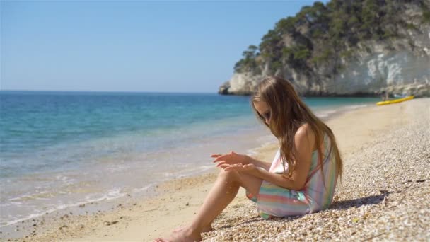 Χαριτωμένο κοριτσάκι στην παραλία κατά τη διάρκεια των καλοκαιρινών διακοπών — Αρχείο Βίντεο