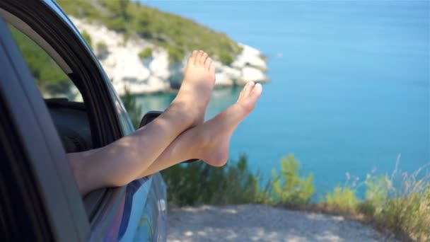 Primer plano de pies de niña que muestra desde el fondo de la ventana del coche mar — Vídeo de stock