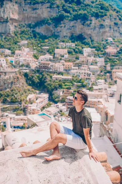 Sommarsemester i Italien. ung man i Positano byn på bakgrunden, Amalfikusten, Italien — Stockfoto