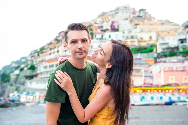 Férias de verão na Itália. Casal jovem em Positano aldeia ao fundo, Costa Amalfitana, Itália — Fotografia de Stock