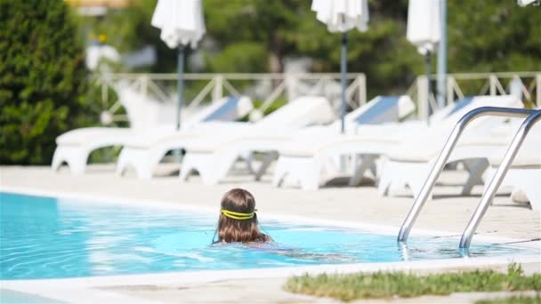 Adorable little girl swimming at outdoor swimming pool — Stock Video