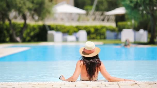 Büyük yüzme havuzunda bikinili genç kadın — Stok video