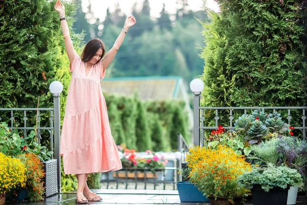 Giovane ragazza in un giardino fiorito tra belle rose. Odore di rose — Foto Stock