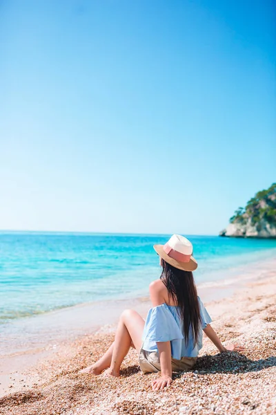 Plajda uzanan kadın yaz tatilinin tadını çıkarıyor ve denize bakıyor. — Stok fotoğraf