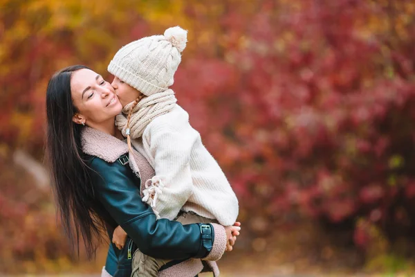 Klein meisje met mam buiten in park in de herfst dag — Stockfoto