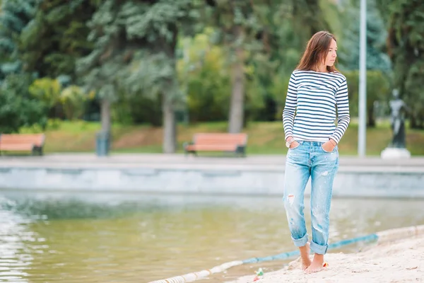 Joven mujer feliz caminando cerca del lago en el cálido día de otoño —  Fotos de Stock