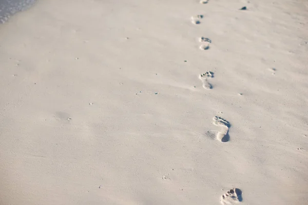 Menschliche Fußabdrücke am weißen Sandstrand — Stockfoto