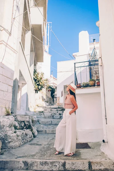 Girl tourist walks outdoors in narrow street — Stock Photo, Image